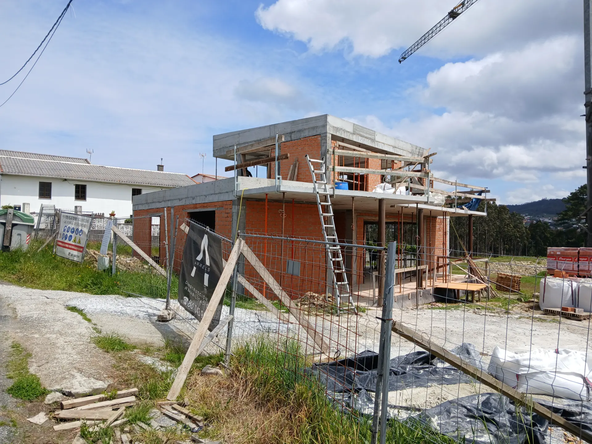Vivienda en construcción en Valdoviño con el cartel de Arrels en el vallado